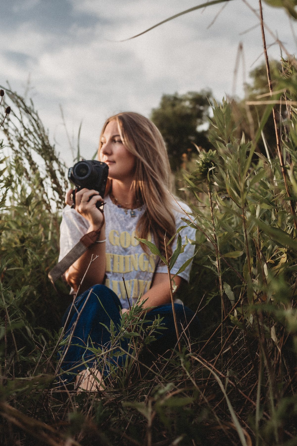 Amanda Appleton, photographer behind Core Photography by AA, in a wildflower field with her camera